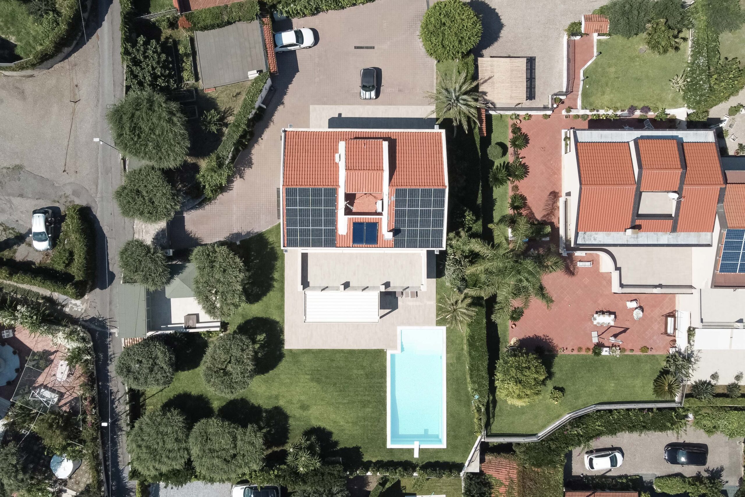 casa con pannelli fotovoltaici, tenda e piscina nel giardino